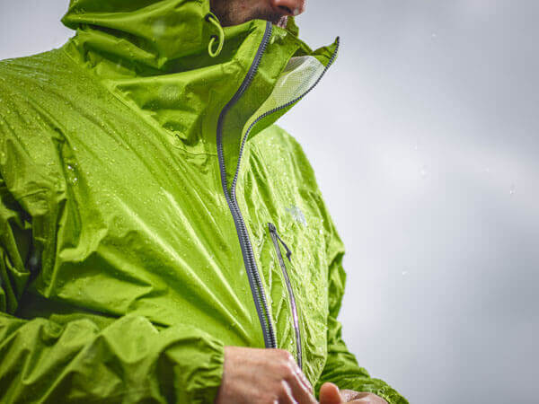 Grüne Regenjacke mit wasserabweisender Funktion. Imprägnierung wird geprüft.