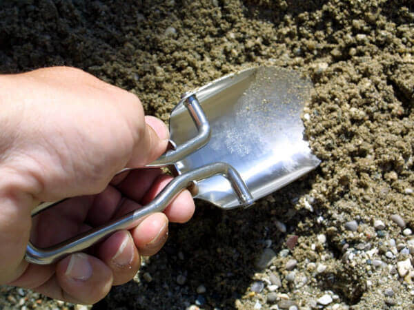 Kleine Metall-Schaufel buddelt in der Erde