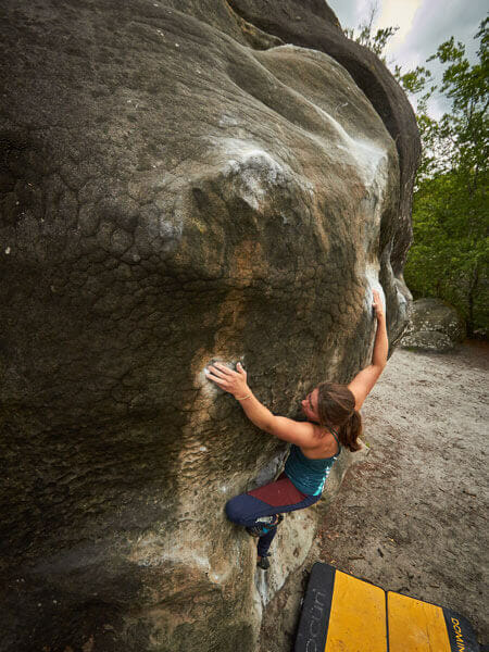 Bergfreundin Mia beim Bouldern in Fontainebleau. Dort findet man hauptsächlich Sandstein vor.