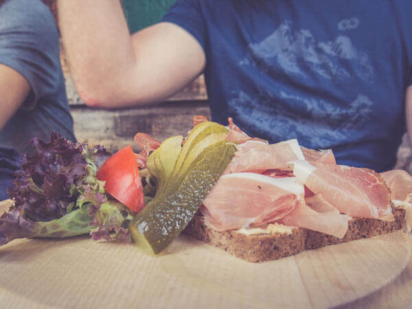 Vesperbrett mit Brot, Wurst und Salat.