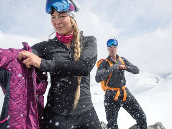 Outdoorsportler ziehen sich an während es schneit.
