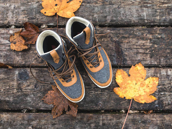 Grau orangene Boots auf Laub