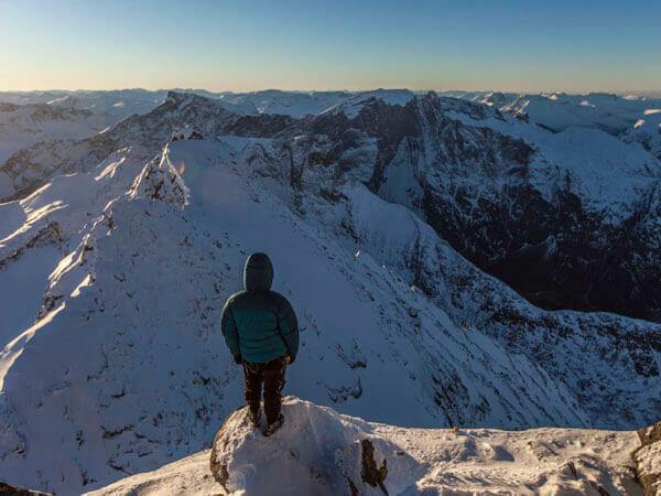 Ein Wanderer auf dem Gipfel eines verschneiten Berges