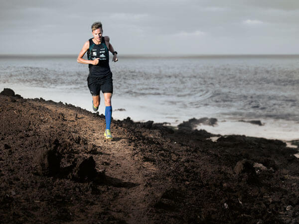 Ein Mann joggt an der Küste entlang