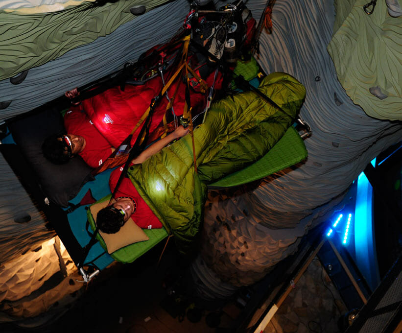 Zwei Männer liegen im Schlafsack auf einer Portaledge