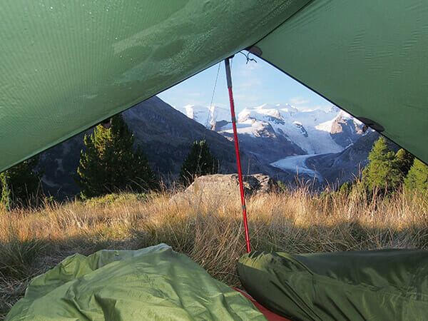 Blick aus einem Tarp-Zelt auf einen schneebedeckten Berg