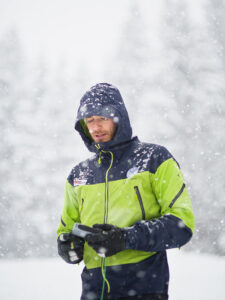 Bergfreund im Schneegestöber mit Winterjacke.
