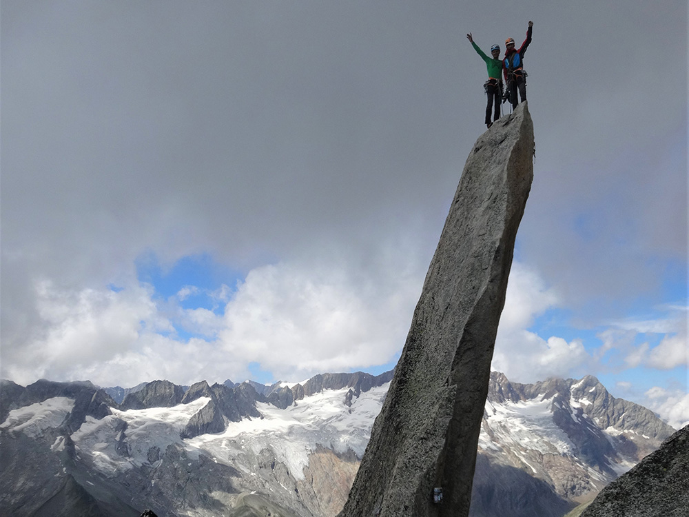 Zwei Bergsteiger auf der Gipfelnadel des Salbit
