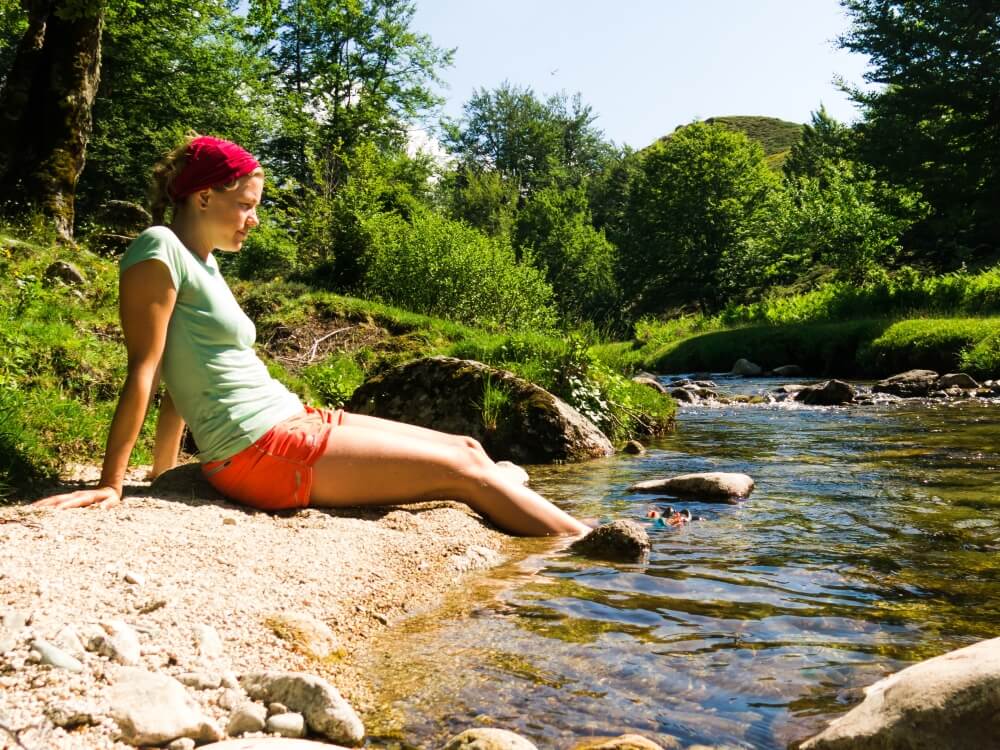 Frau sitzt am Fluss