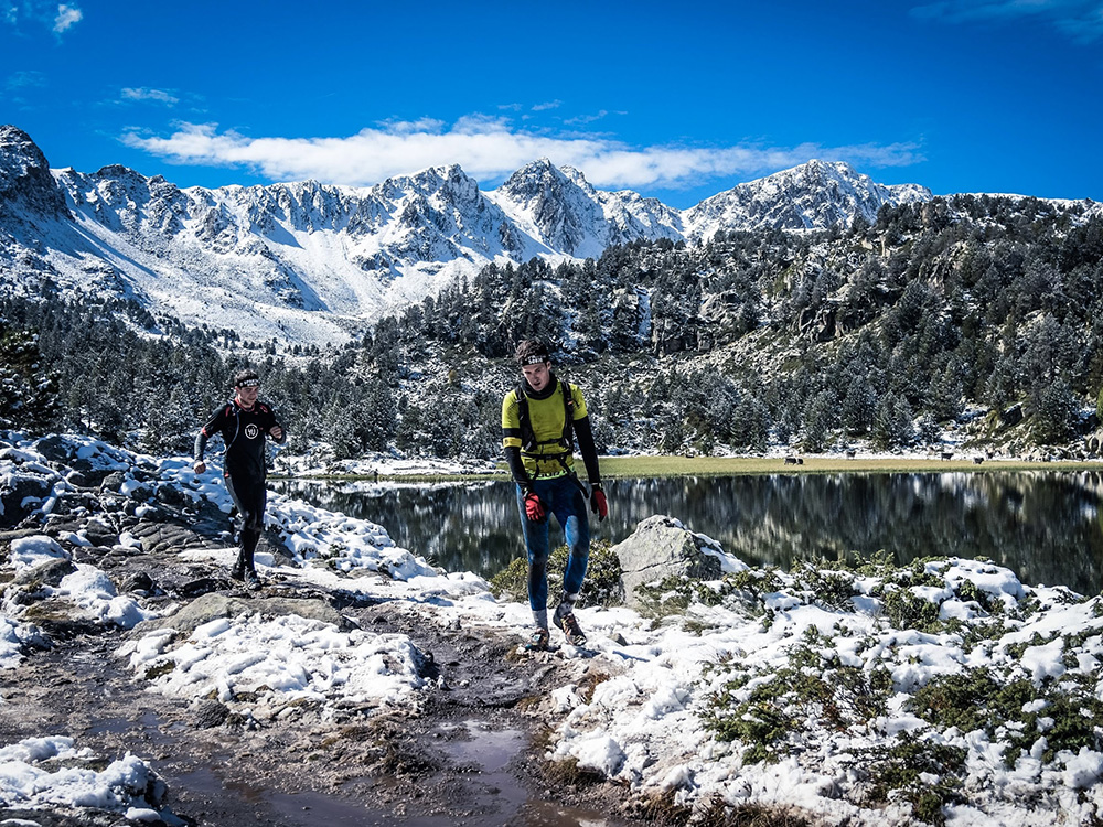 Trailrunner im Schneematsch tragen dünne Klaufbekleidung aus Merino und Kunstfaser.