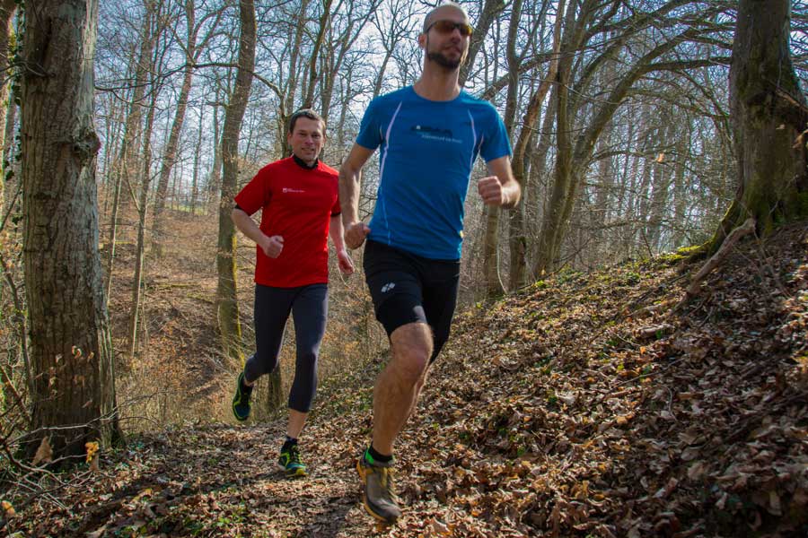 Zwei Männer laufen durch den Wald
