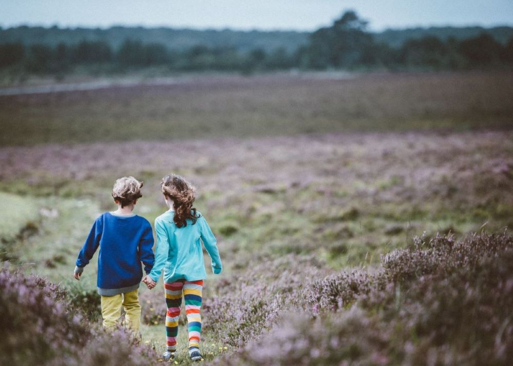 Zwei Kinder wandern Hand in Hand