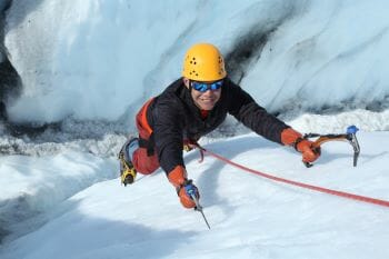 Mann klettert mit Steigeisen.