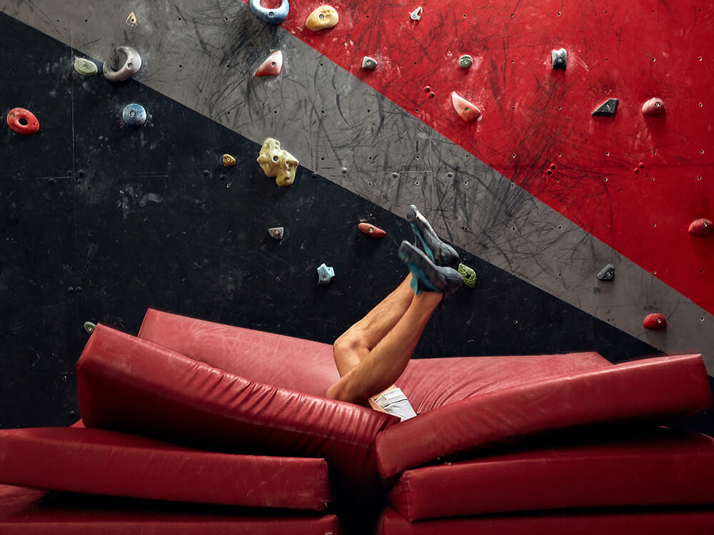 Kletterer fällt von der Boulderwand in Matten