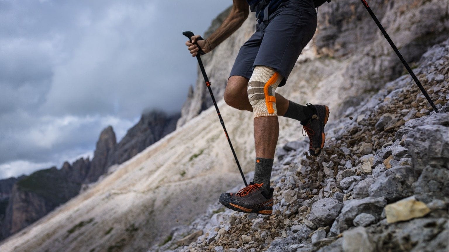 Wanderer in den Bergen geht mit der Bauerfeind Kniebandage bergab