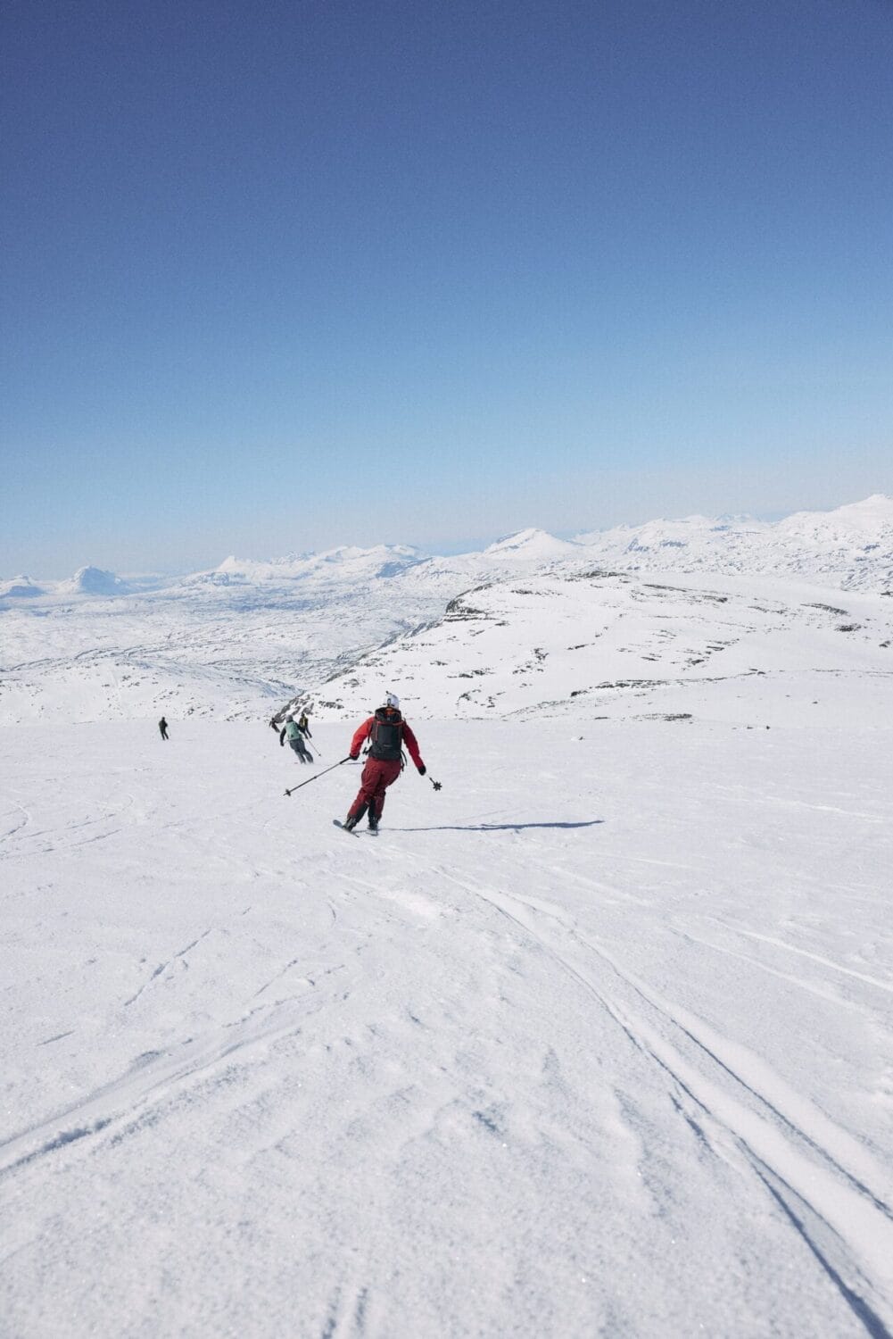 Gruppe von Skifahrern fahren eine Piste runter