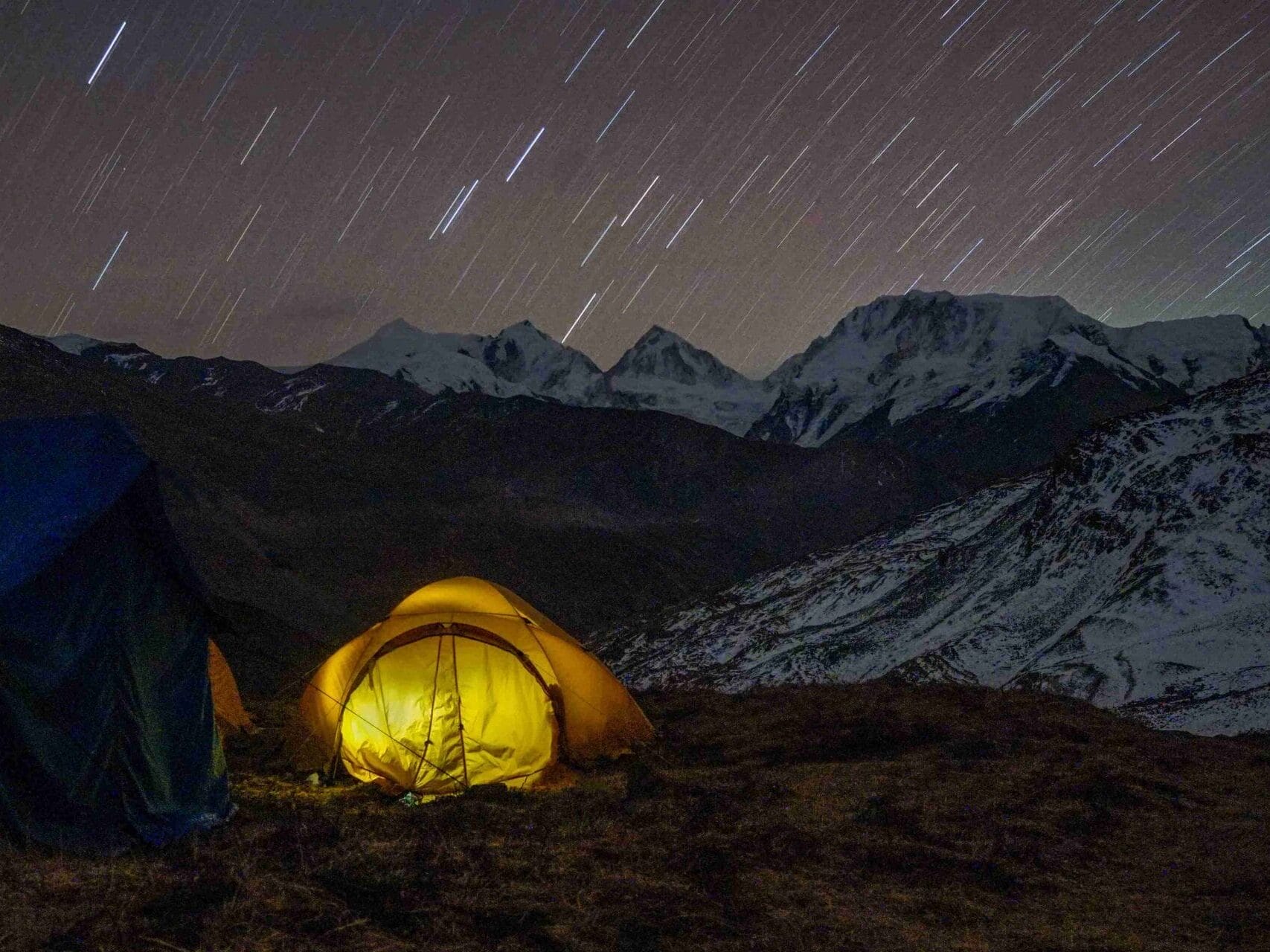 Zwei Zelte in der Natur in der Himlung-Region bei Nacht mit leuchtenden Sternen am Himmel