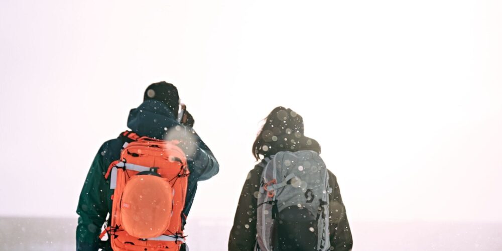 Mann und Frau schauen auf verschneite Landschaft