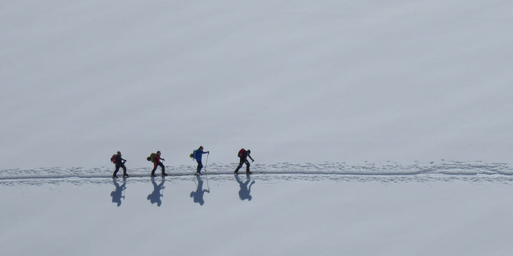 Skitourengruppe beim Aufstieg im Schnee